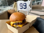 The 99 Burger from Yankee Stadium. Named for star Yankee outfielder Aaron Judge (whose uniform number is 99), the burger features two 4 oz. American wagyu beef patties, American cheese, caramelized onions, secret sauce and dill pickles on a brioche bun.
