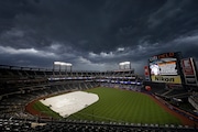 Storm clouds move in with the tarp covering the field before a scheduled game between the Milwaukee Brewers and the New York Mets at Citi Field on Tuesday, July 6, 2021 in New York.